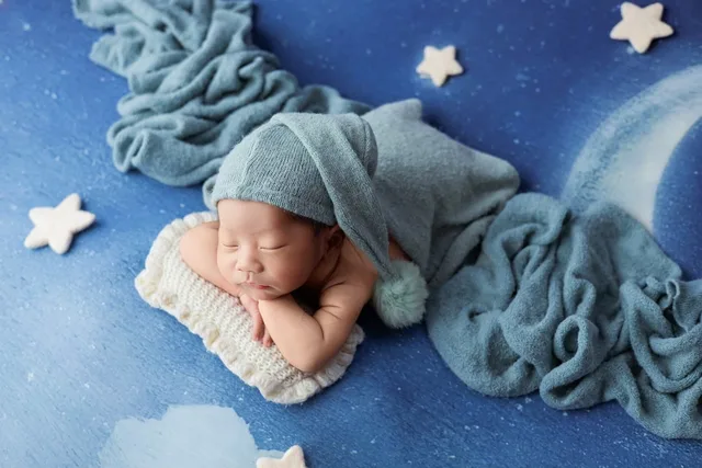 newborn, creative photography, sleeping baby, blue color, moon and stars, baby studio, peaceful, baby hat, swaddle wrap, moonlight, newborn in studio, soft fabric, baby photography, fabric with stars, night sky, newborn with hat, snug baby, baby portrait, dreamy, newborn pose. YouTube launch readiness review for parenting creators