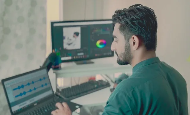 Man working in office on editing software with dual displays, laptop, and professional setup. Parenting creators supplier comparison: caption workflows